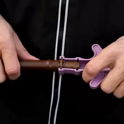 Conector de mangueira de jardim em plástico castanho e lilás nas mãos