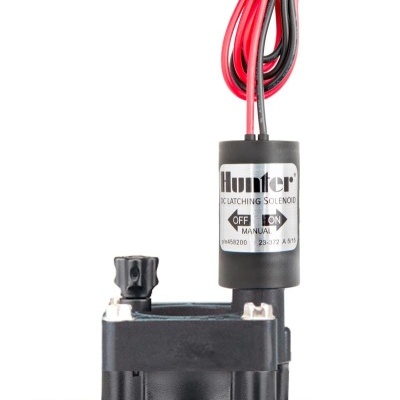 Válvula solenoide preta da marca Hunter com fios vermelhos e pretos e etiqueta na parte superior