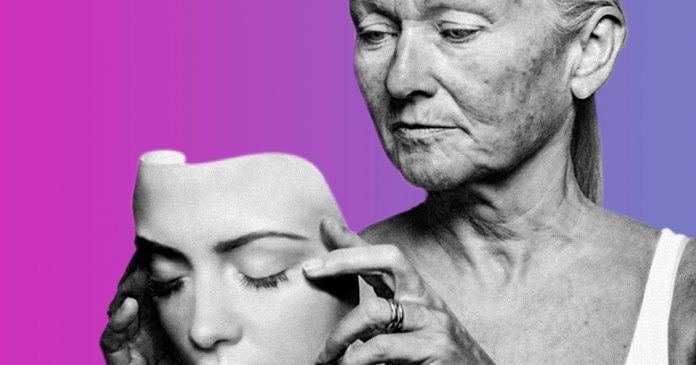 Mulher idosa segurando uma máscara de rosto jovem, fundo rosa e roxo.