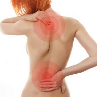 Mulher com dor nas costas, círculos vermelhos destacados na parte superior e inferior das costas