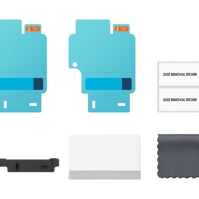 Kit de proteção de ecrã com películas azuis, adesivos, espátula e pano cinzento.