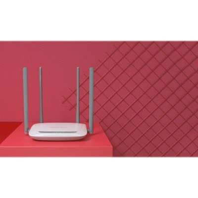 Roteador branco com quatro antenas cinzentas sobre superfície vermelha e fundo vermelho decorativo