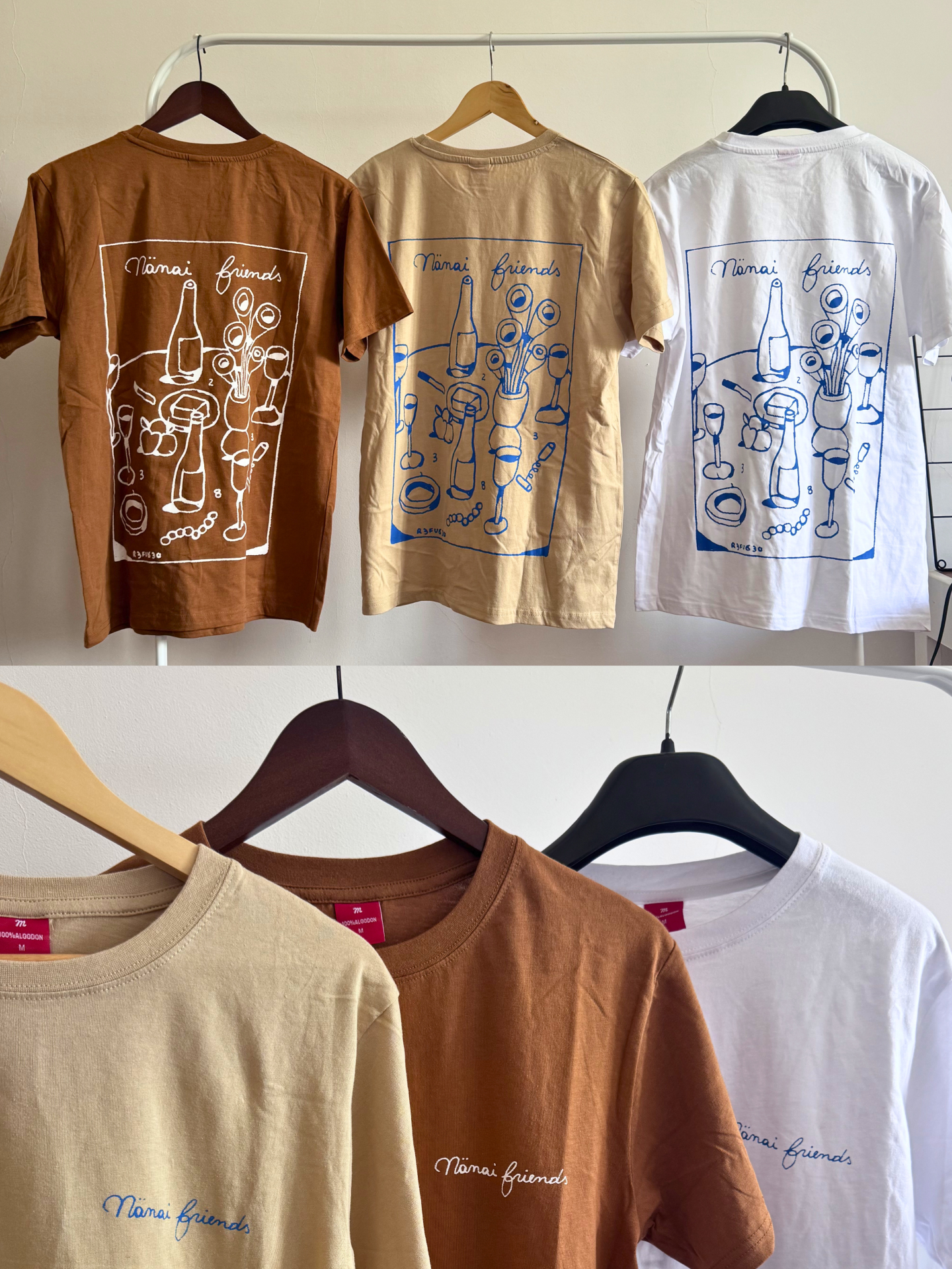 Três t-shirts castanha, bege e branca com estampa Nänäi friends penduradas.
