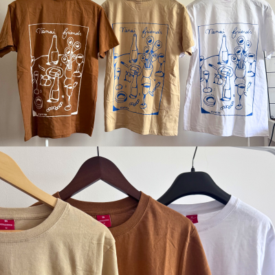 Três t-shirts castanha, bege e branca com estampa Nänäi friends penduradas.