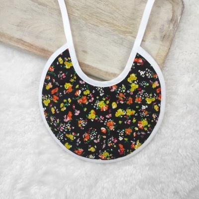 Babete redonda preta com flores coloridas e bordas brancas