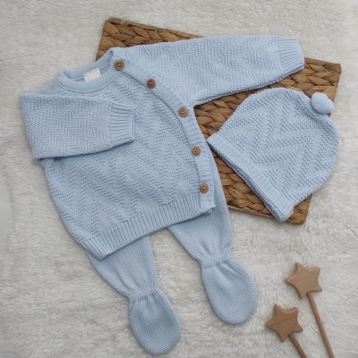 Conjunto de roupa de bebé azul claro em tricô com casaquinho, calças e gorro com pompom