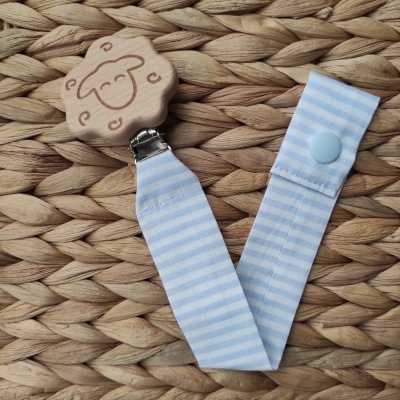 Prendedor para chucha de madeira com desenho de ovelha e fita azul com riscas brancas