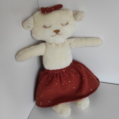 Peluche de urso creme com saia vermelha e laço