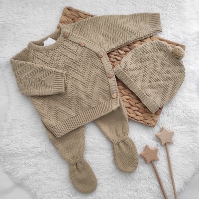 Conjunto de roupa de bebé bege em malha com padrão de espinha de peixe e gorro com pompom