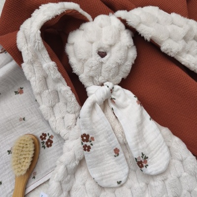 Urso de pelúcia branca com orelhas de tecido floral, tecido terracota e escova de madeira.