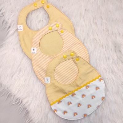 Babetes amarelos para bebé com padrões variados e fechos amarelos