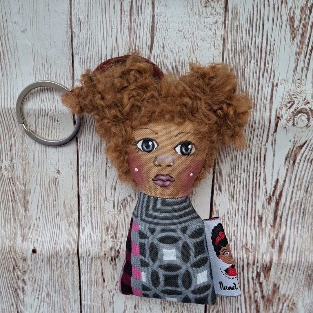 Porta-Chaves Boneca – Ternura e Estilo Afro Porta-chaves de boneca com rosto bordado e vestido estampado