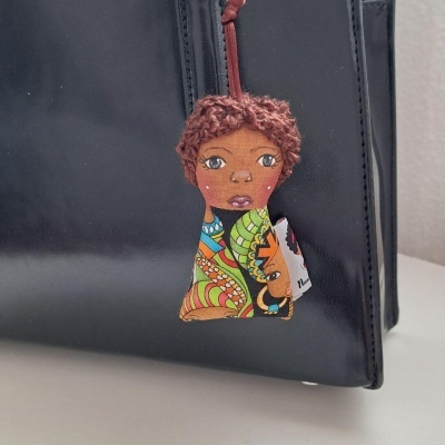 Pingente decorativo em tecido colorido pendurado em bolsa preta