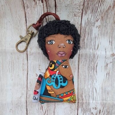 Chaveiro em tecido com rosto de boneca e padrão étnico colorido