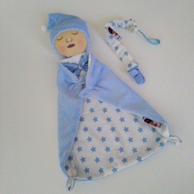 Manta para bebé azul com padrão de estrelas e prendedor de chupeta correspondente.