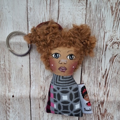 Porta-chaves de boneca com rosto bordado e vestido estampado