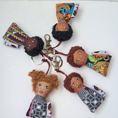 Porta-chaves em forma de bonecas coloridas com padrões variados sobre fundo branco.