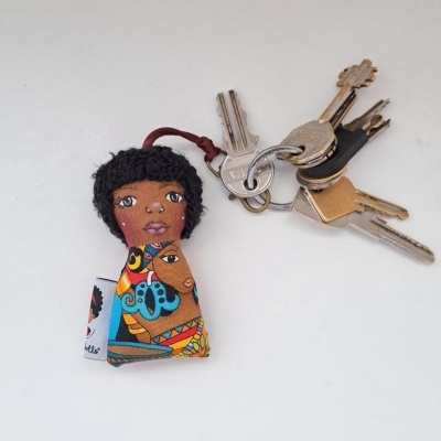 Chaveiro tecido colorido com figura feminina e molho de chaves