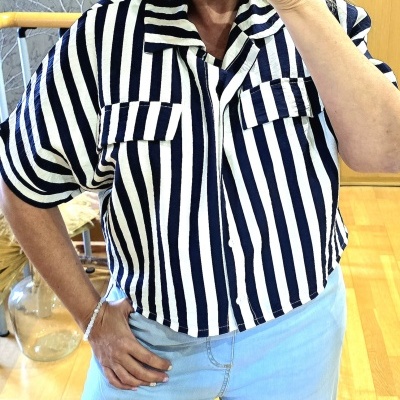 Camisa feminina às riscas verticais preta e branca de tecido leve com mangas curtas e bolsos no peito.