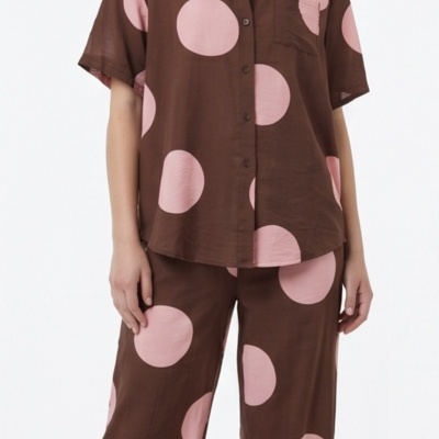 Conjunto castanho com bolinhas cor-de-rosa, camisa manga curta e calças largas.