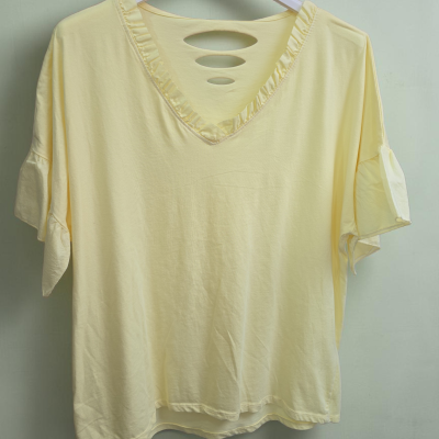 T-shirt amarela clara com golas e recortes, pendurada em cabide