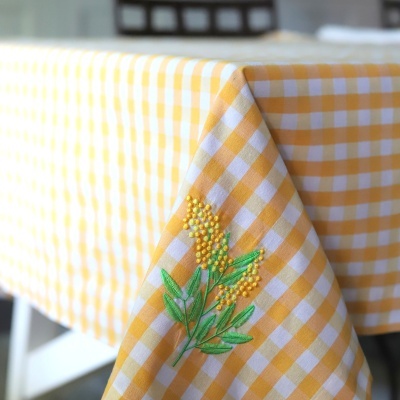 Toalha de mesa amarela e branca com bordado de flores