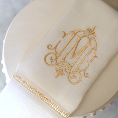 Toalha branca bordada com letras douradas JM