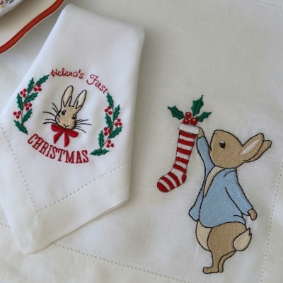 Toalhas brancas com bordados de coelho e motivos natalícios.