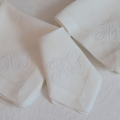 Guardanapos brancos de tecido com monograma bordado em branco