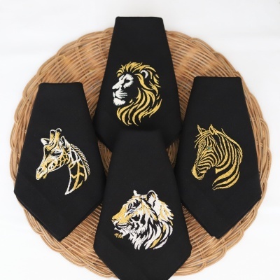 Guardanapos pretos bordados com animais dourados sobre suporte de verga