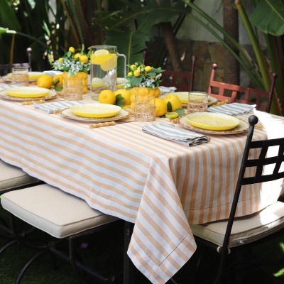 Mesa posta com toalha às riscas brancas e castanhas e decoração com limões