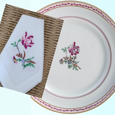 Guardanapo branco e prato creme com borda e flor em rosa