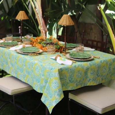 Mesa de refeição ao ar livre com toalha colorida e pratos verdes decorativos