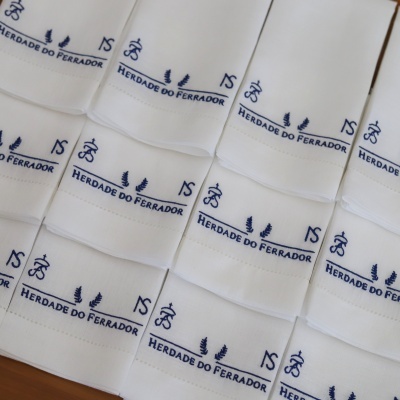 Panose de cozinha brancos com bordados azuis e texto HERDADE DO FERRADOR