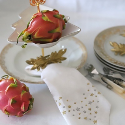 Fruta do dragão em suporte com pratos e guardanapo bordado