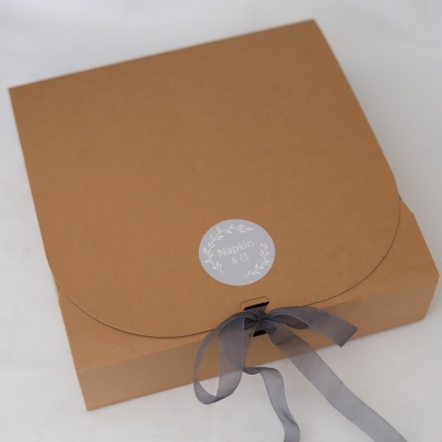 Caixa de papel castanho com fita cinza e etiqueta Napkin & Co