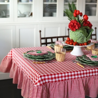 Toalha de mesa xadrez vermelha e branca com decoração de prato e flores