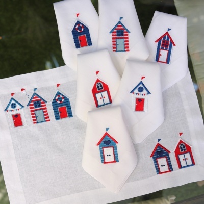 Servilletas y camino de mesa con bordados de casetas de playa rojo, azul y blanco