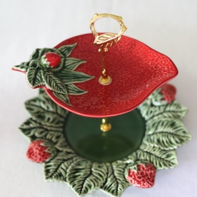 Suporte cerâmico decorativo para sobremesas com temas de folhas e morangos.
