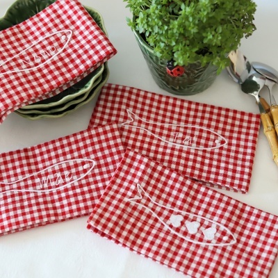 Guardanapos de tecido xadrez vermelho e branco bordados com peixes e texto em branco