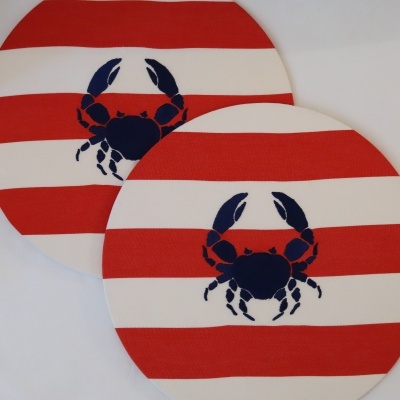 Dois tapetes redondos com riscas vermelhas e brancas e caranguejo azul.