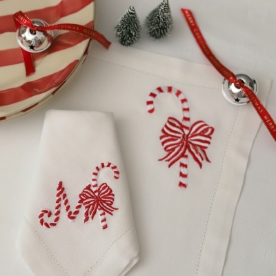 Guardanapos de tecido branco com bordado de bengala de Natal vermelho e branco com laço vermelho