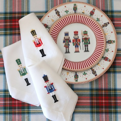 Pratos e guardanapos com padrão de soldadinhos em mesa com toalha xadrez