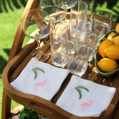 Bandeja de madeira com copos, guardanapos bordados e limões