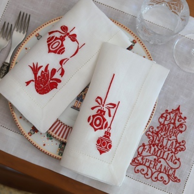 Guardanapos brancos de tecido com bordados vermelhos natalícios