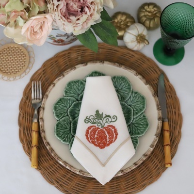 Conjunto de mesa com prato, guardanapo bordado, talheres com cabo de bambu, base de rattan e flores