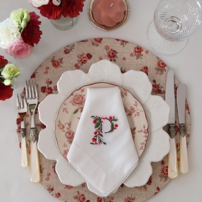 Mesa posta com louça floral e talheres com cabos de madrepérola