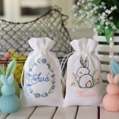 Dois sacos de tecido bordados com motivo de flores e coelho, com as palavras 'Avó' e 'Mana'