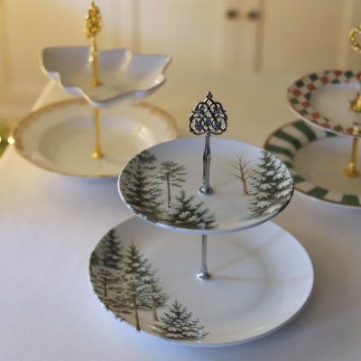 Suportes para bolos de cerâmica com hastes metálicas decorativas e padrões variados em fundo branco.