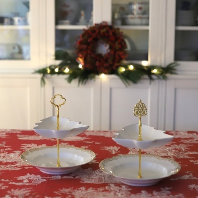 Dois suportes de porcelana branca e dourada para servir com base redonda e prato em forma de árvore de Natal.